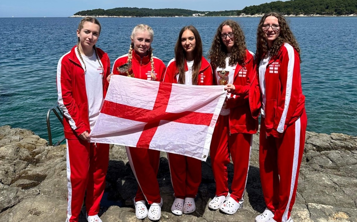 Lucie Roberts, Lucy Frudd, Elisia McCaslin, Ella Tingle and Chloe Tingle holding an England flag in Croatia.